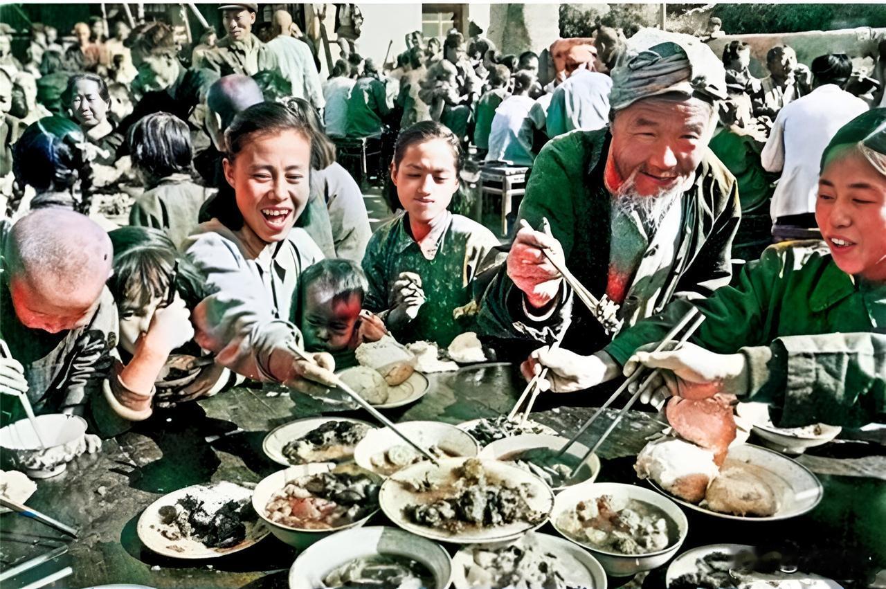 1958年，人民公社社员热热闹闹地聚在一起吃“大锅饭”。老人、孩子、妇女的脸上露