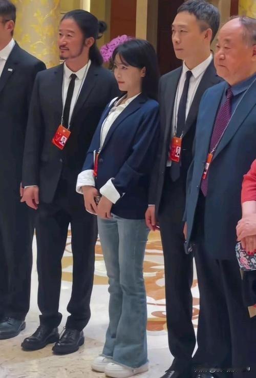 李子柒站在吴京和张译中间，娇小可人，秀腿站的笔直，像个纯情的中学生，颜值还是扛住