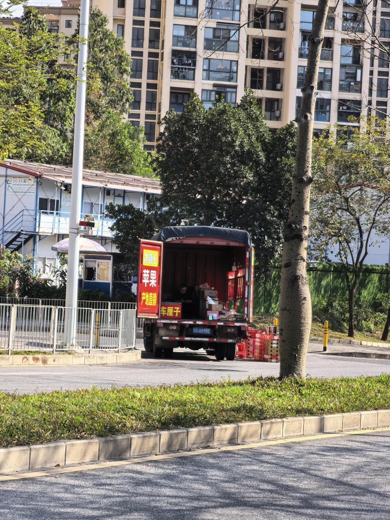 年关了，出门人真难。
深圳某一路口，有商贩拉了车厘子，新疆阿克苏苹果，大枣等在那