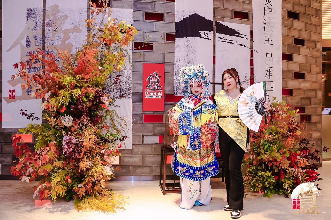  身着中式元素的服装，从瓦片签到，非遗拓印体验，到京剧演唱、变脸艺术表演，沉浸式