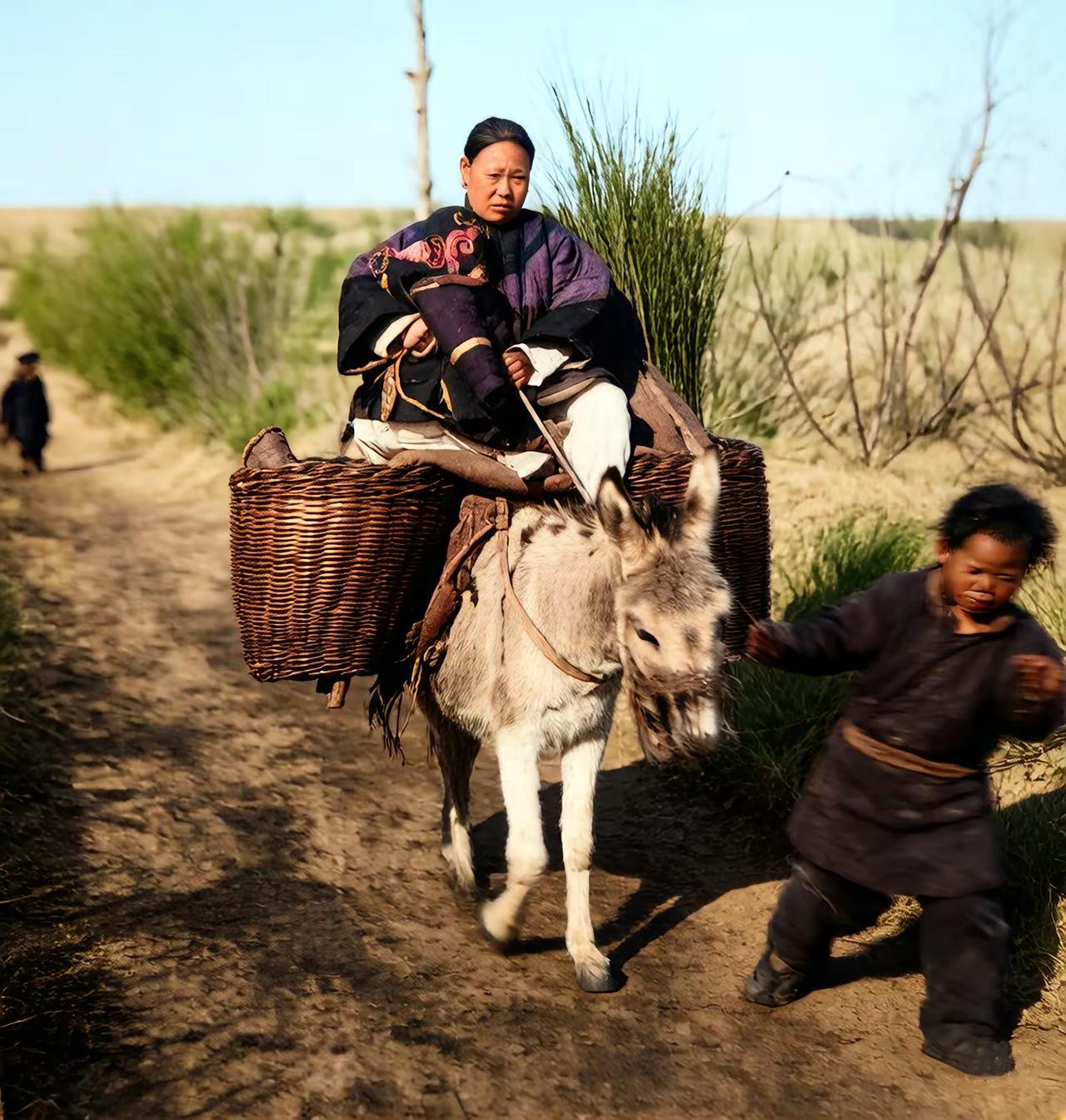 民国时期，一名西洋摄影师在旅行途中看到的一幅场景。一名衣着体面的年轻妇人乘驴出行
