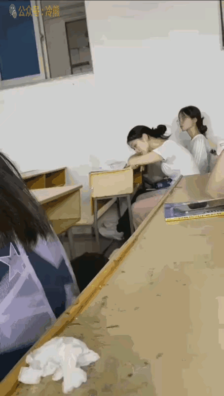 趴在桌子上那个这个女子，也不知道是学生，还是学生的家长，看这桌子，像是小朋友坐的