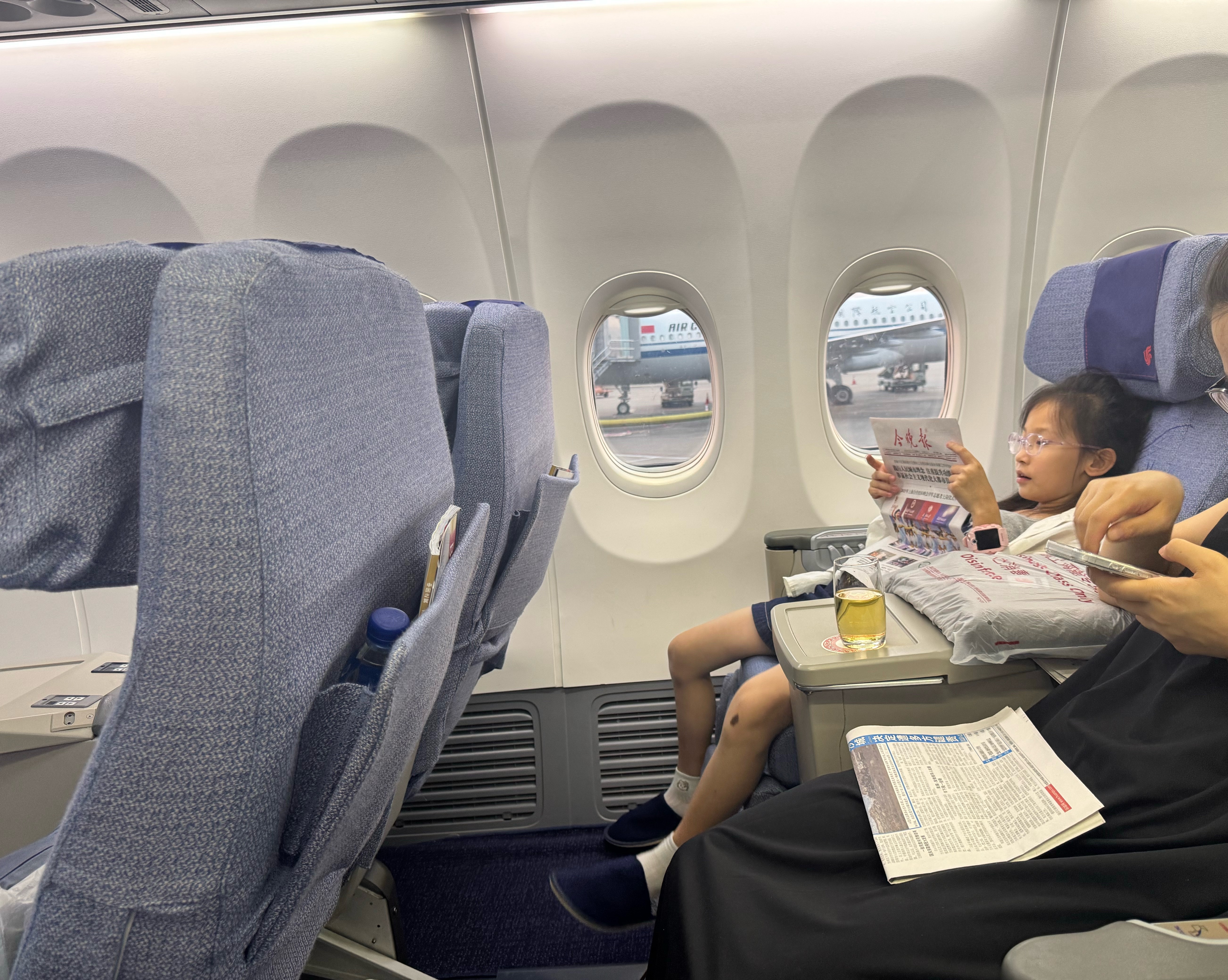 装模作样看上报纸了。其实脑子里不知道在想什么呢？估计在想回家之后要以什么理由逃避