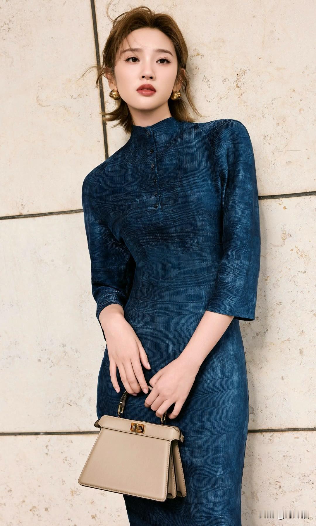 唐艺昕身着优雅蓝调连衣裙，手挽精致手提包，这造型将都市女性的魅力展现得淋漓尽致！