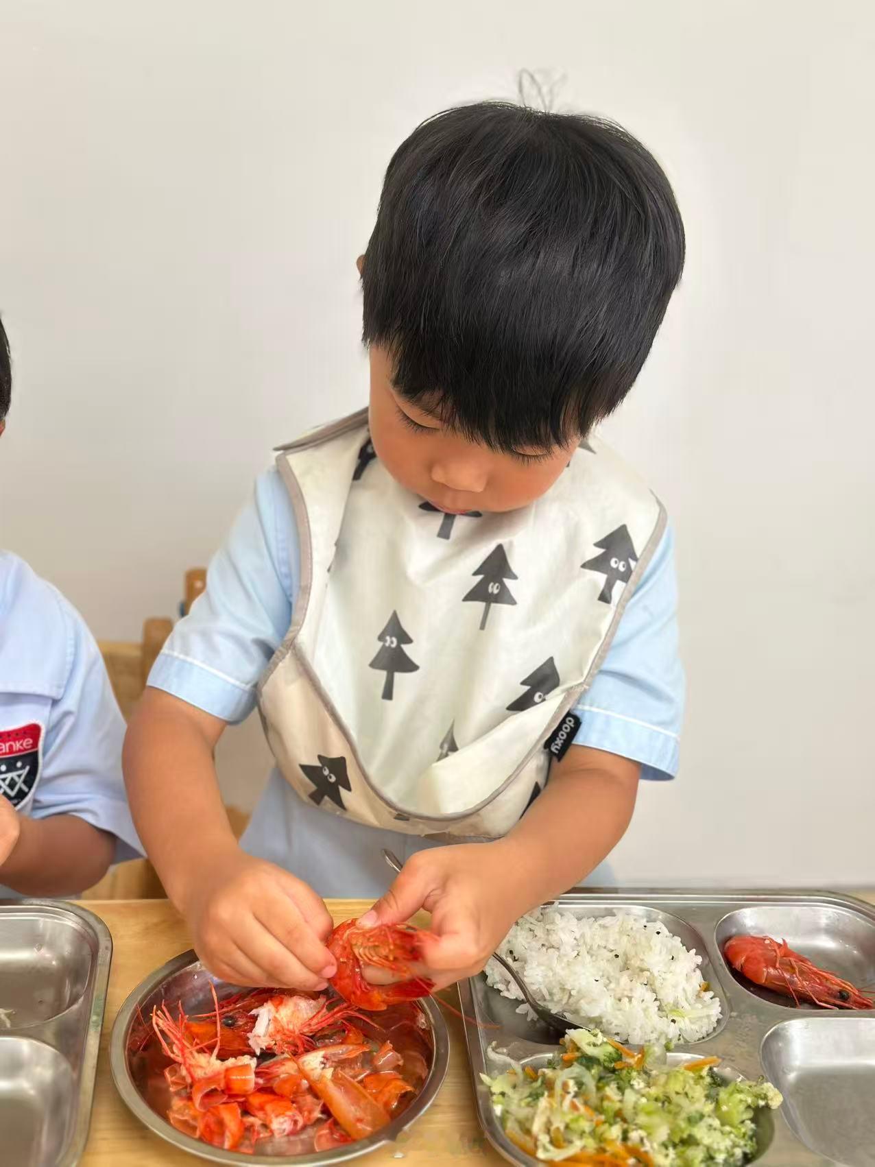 在家还动不动要奶奶喂， 在幼儿园“帮小朋友剥虾”....看来谁都有两幅面孔～ ​