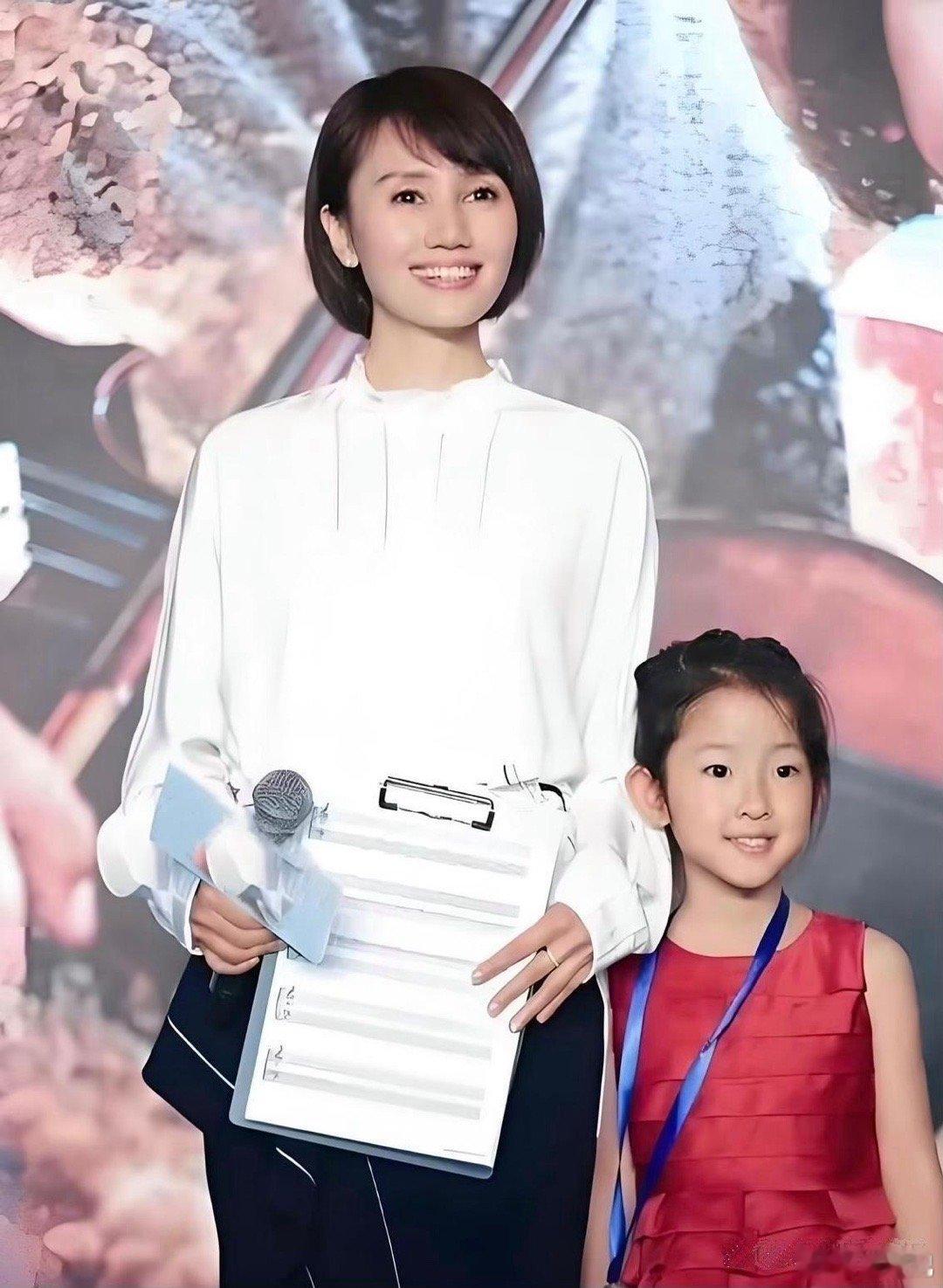 袁泉和夏雨的女儿夏哈哈身穿红色裙子，与妈妈同台亮相。她的大眼睛灵动有神，像极了妈