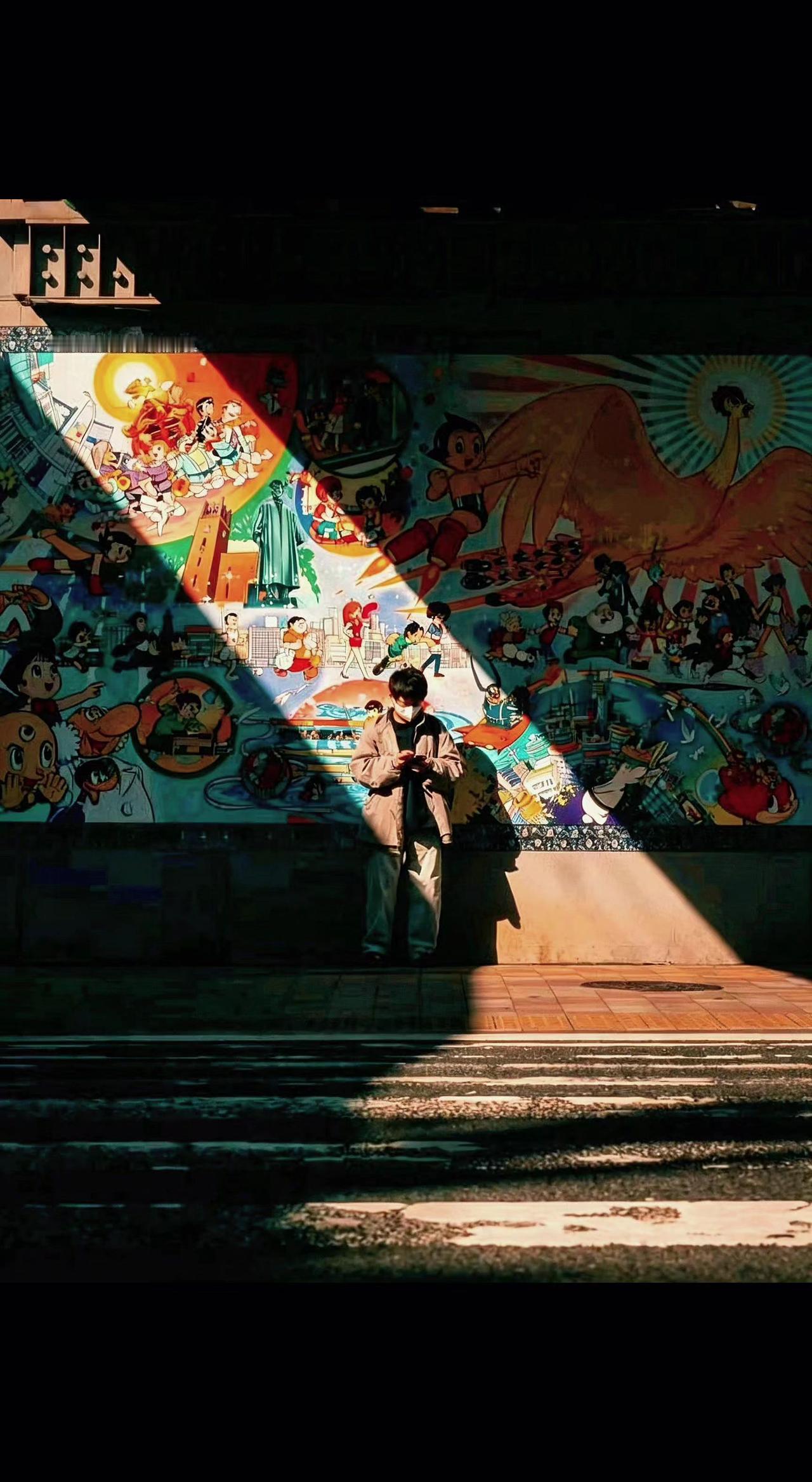 🌞光影把壁画切成两半，一半人间烟火，一半神明游戏✨ 他站在明暗交界处，像幅会呼