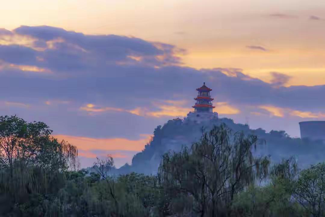 天空是永不重复的调色盘，建筑群化作剪影画框。北京城长安街西端的石景山无论是朝霞满