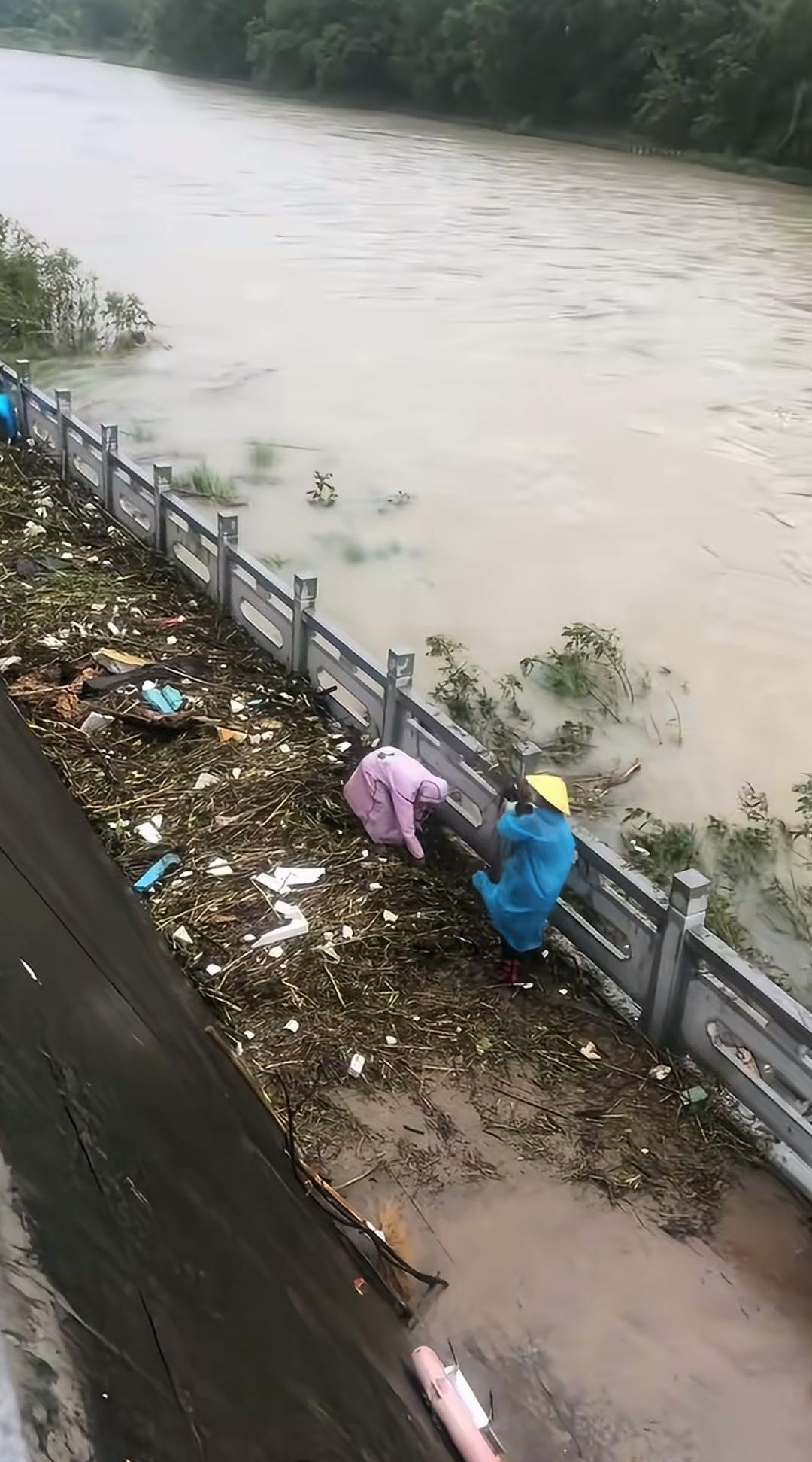 洪水退去后清理岸边杂物，工人为何反倒把东西扔回河里？
洪水过境，河岸上堆了不少被