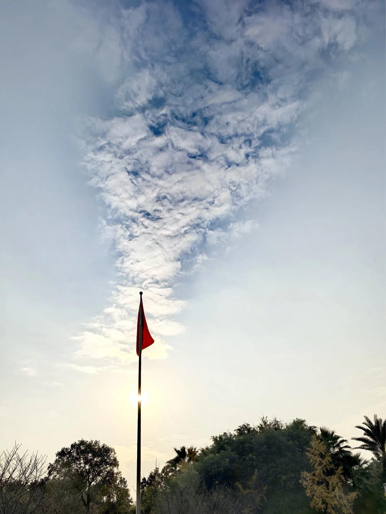 太阳上方，一缕云烟飘扬。
云烟左右呈现雾化，
蓝天却在白云中凸显，
难得一见。