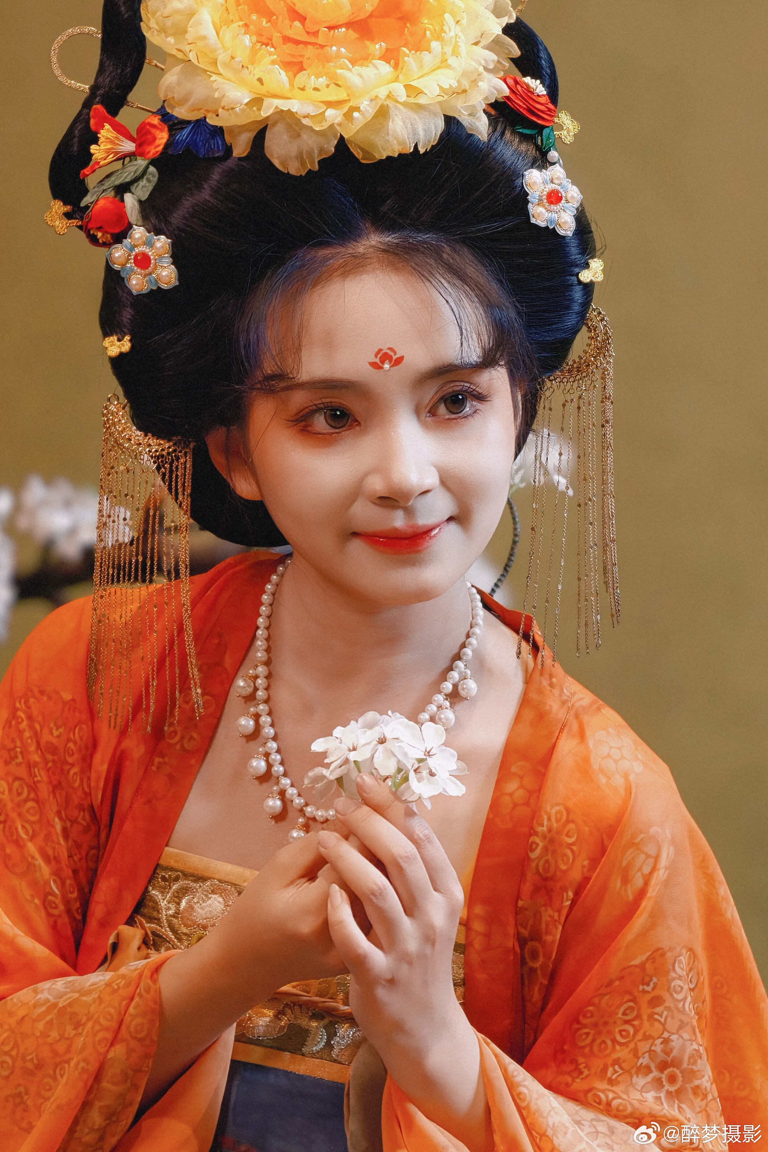 古韵今风，一袭华裳醉千年。  橙蓝相映，花钿步摇，尽显盛唐风华。  执花浅笑，眉