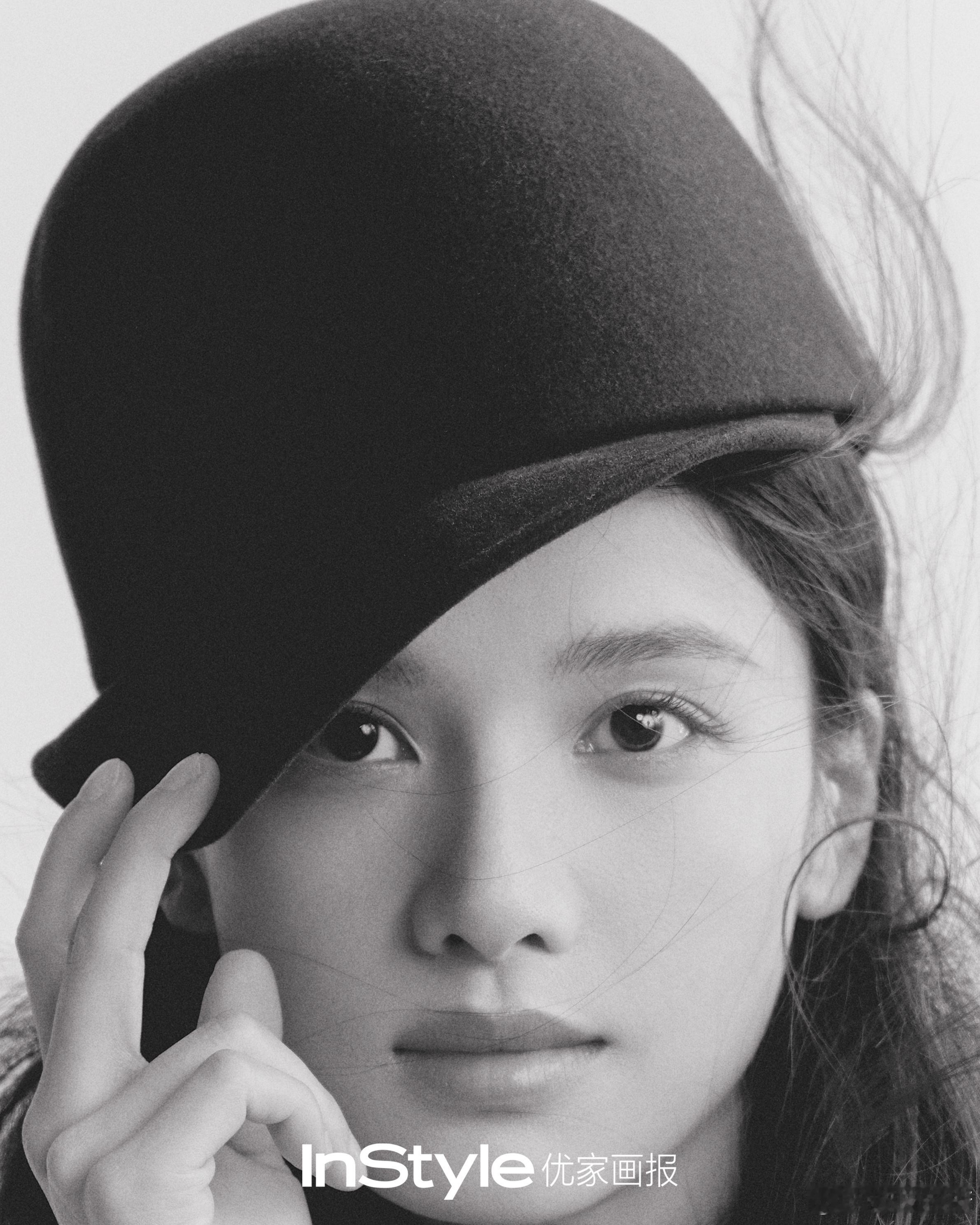 张婧仪帽檐下的清冷眼眸藏着故事，山水间的随性转身皆是风景，红围巾与落叶共舞，针织