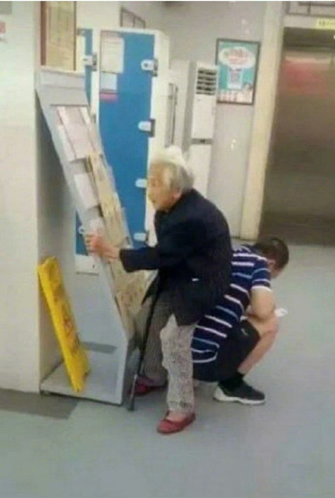 儿子带母亲到医院看病，老人走着走着站不住了，于是儿子就蹲下当起了母亲的“人肉座椅