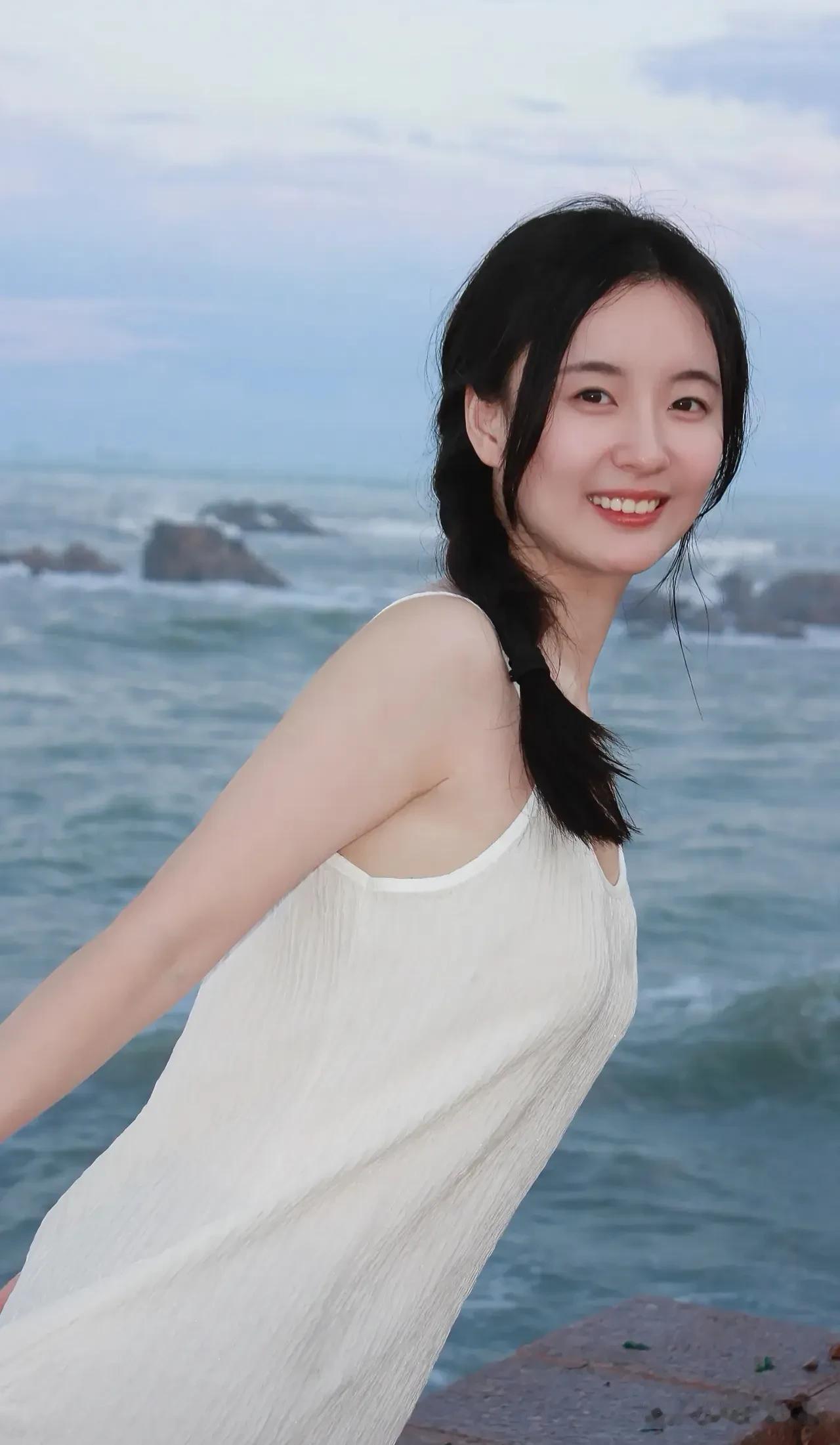 炎炎夏日，海风轻拂，  
女孩漫步沙滩，裙摆随风起舞，  
镜头定格瞬间，笑容比