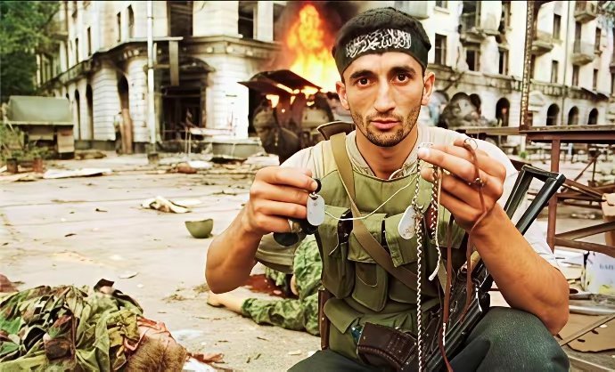 1993年车臣战争中，一位车臣士兵向镜头展示他从身边俄军士兵尸体上扒下的铭牌。军