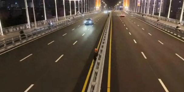 广西钦州子材大桥通车首日，本该顺畅的桥面却上演了惊险一幕：不少市民将硬币抛向车道