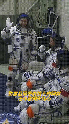 黎家盈在摄影机拍到自己的那一刻，用手指了指衣服上的国旗，还比了个心。

什么意思