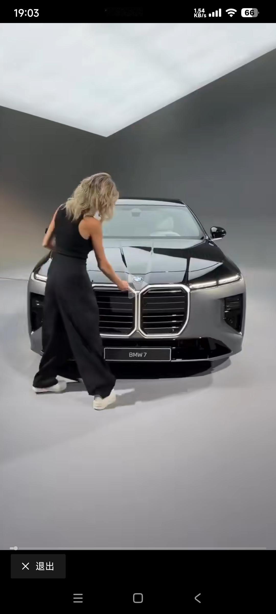 宝马新七系上市
女模特向观众介绍它的前车灯，后车灯，蓝天白云车标，还有车内的彩电