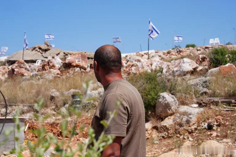 定居者在被占领的约旦河西岸公路沿线升起以色列国旗 以色列定居者在被占领的约旦河西