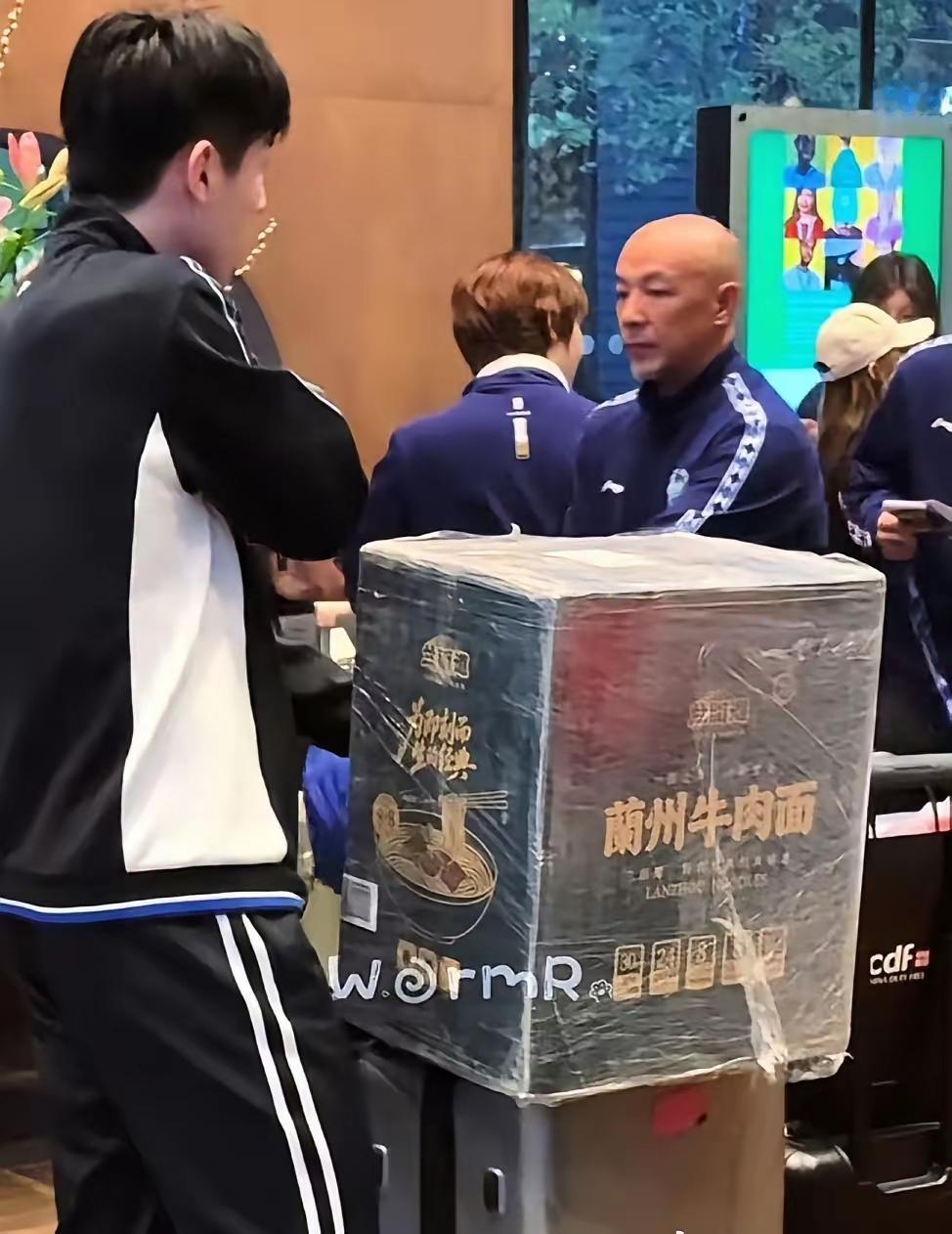 国乒团队出发伦敦，温瑞博和薛飞两人除了自己的行李箱，两人的推车上还各有一箱方便面