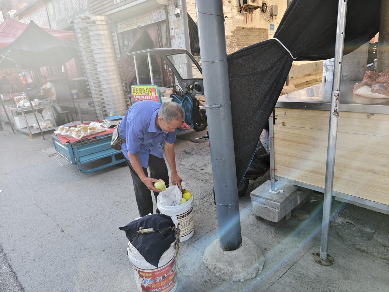今早晨跑返回，在运城市西花园门口，遇到一位大叔，他脚旁放着两桶东西，气喘吁吁站着