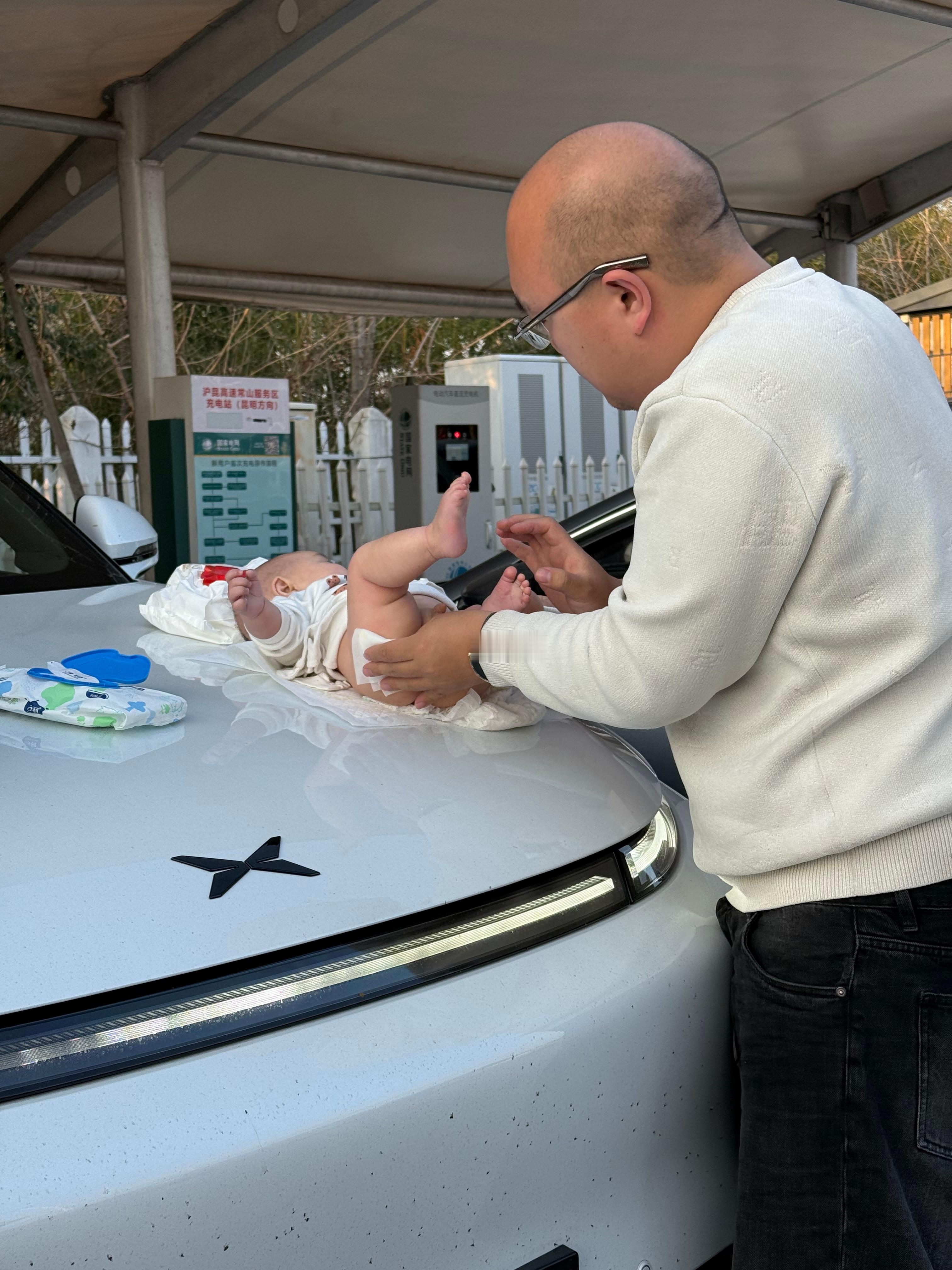 前几天在高速服务区给车子充电的间隙给小九换尿不湿，直接放在小鹏 G9 机盖上换，