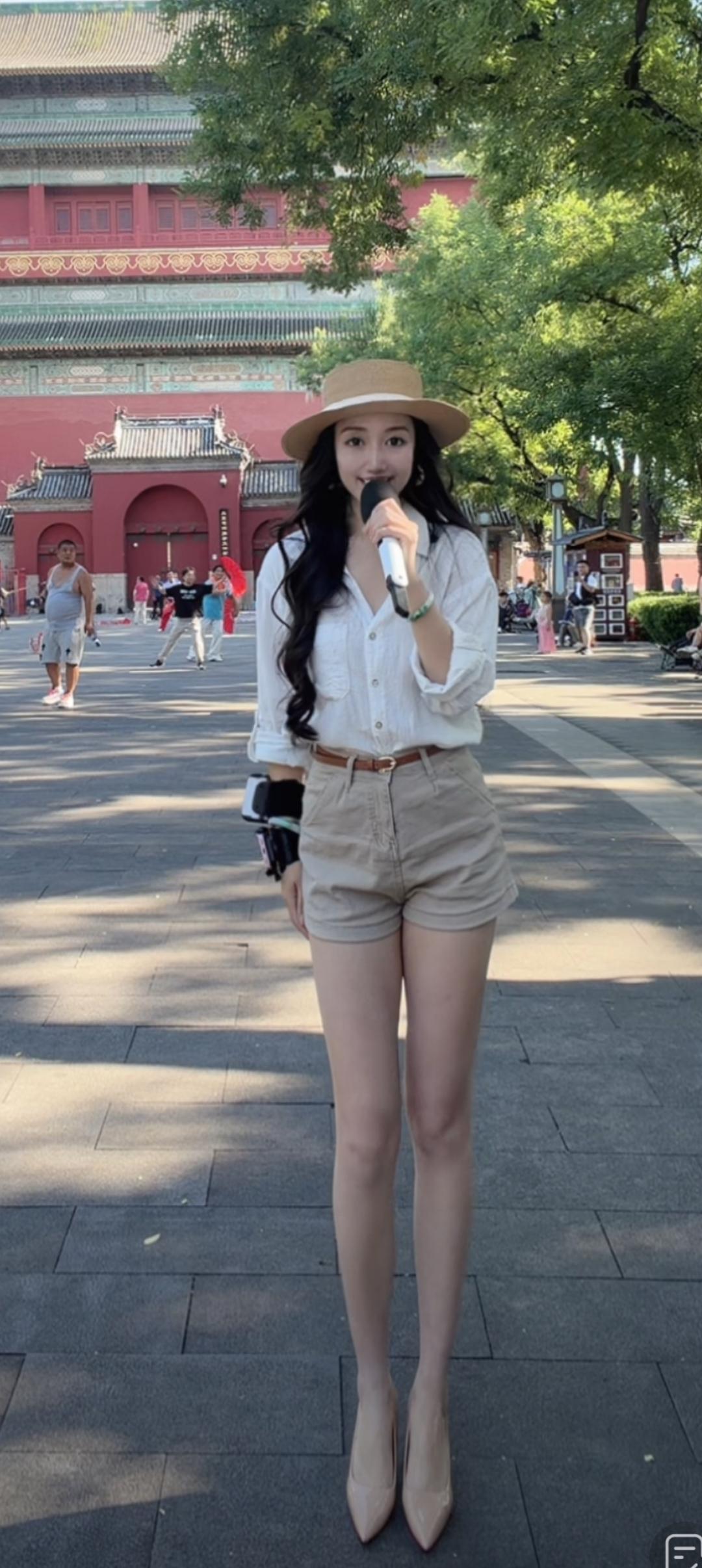 一个女孩在故宫前拿着麦克风。