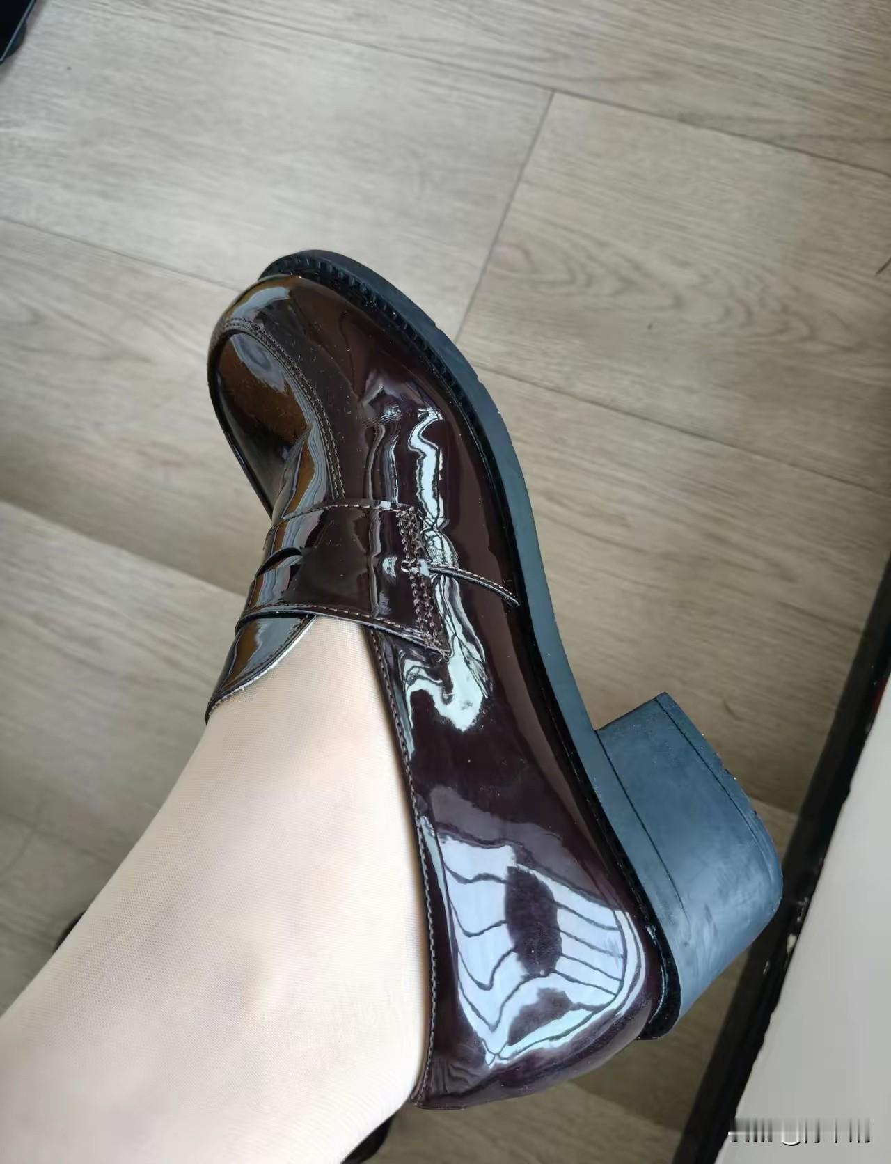 亮面凝光映浅纱，棕霞一抹覆菱花。
鞋头圆润藏风骨，鞋跟方挺踏烟华。
轻抬莲步香尘