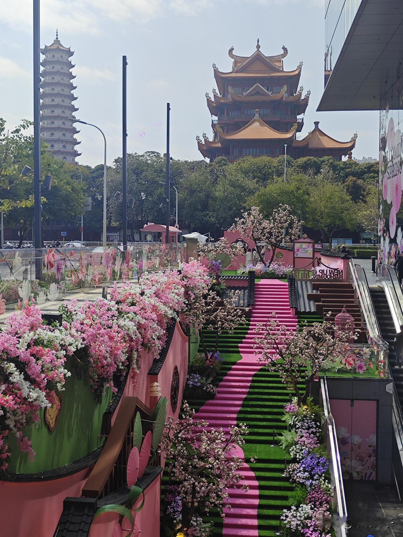 福州华润万象城庙阶，粉黛望春主题装置如约绽放。温柔粉色阶梯蜿蜒而上，一步一景皆是