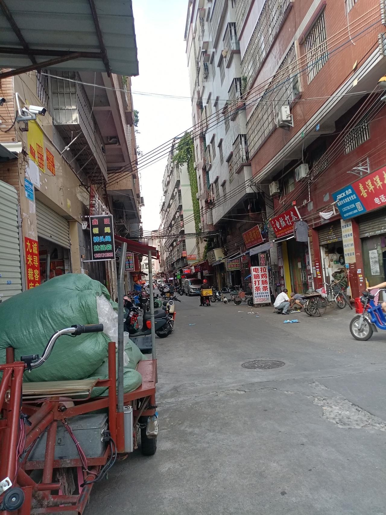 广州海珠区龙潭村南约万年西街主干道，街道上的行人不算很多，但是拉货的三轮车，电动