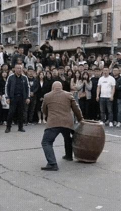 这顶缸的功夫真是绝了！这口缸少说也得有30斤吧？壮汉不但能用头顶，还能用脚顶，甚