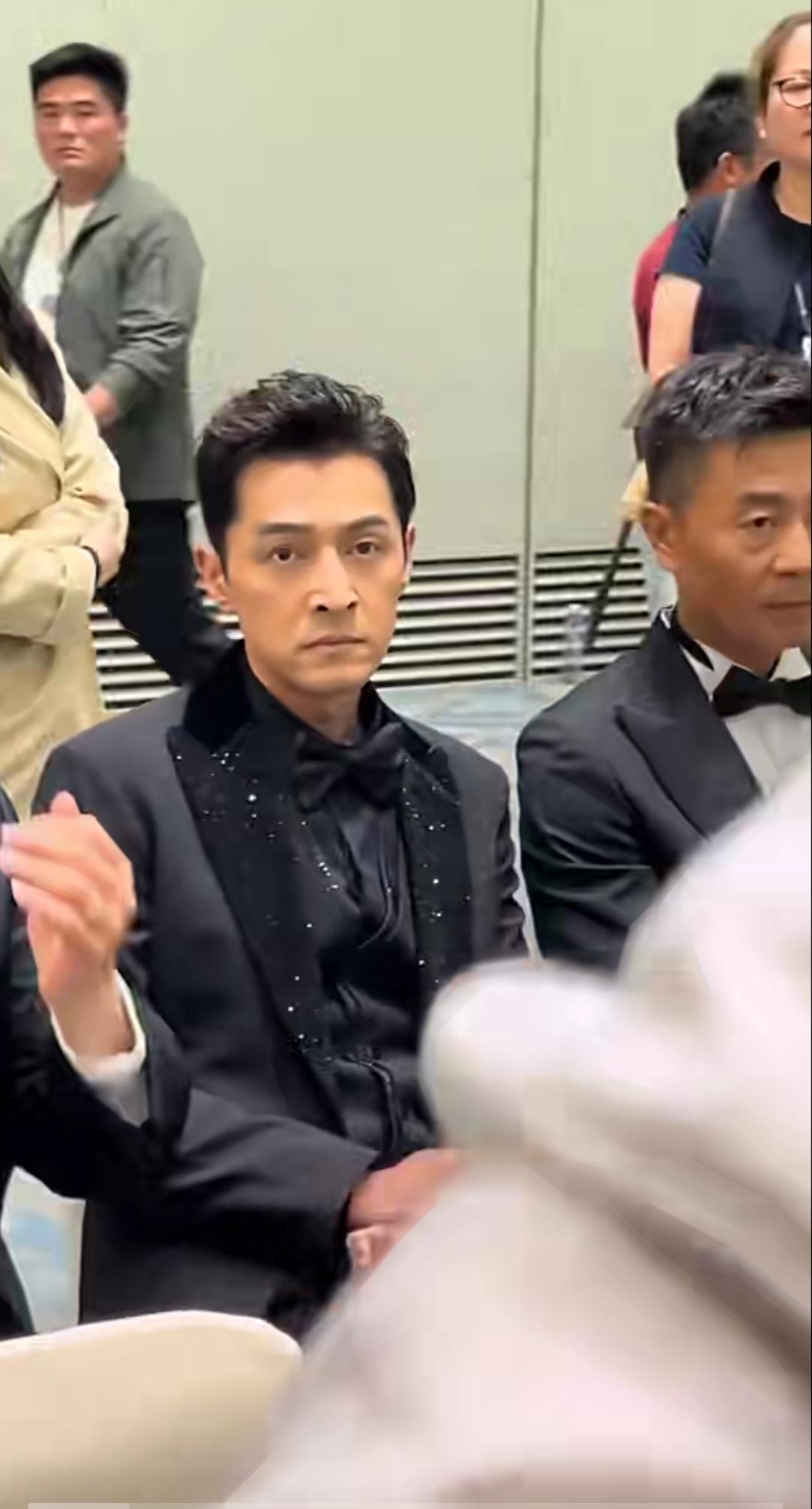 第31届上海电视节白玉兰提名晚宴候场区。
 胡歌身着黑翻领礼服西装，生图镜头下状