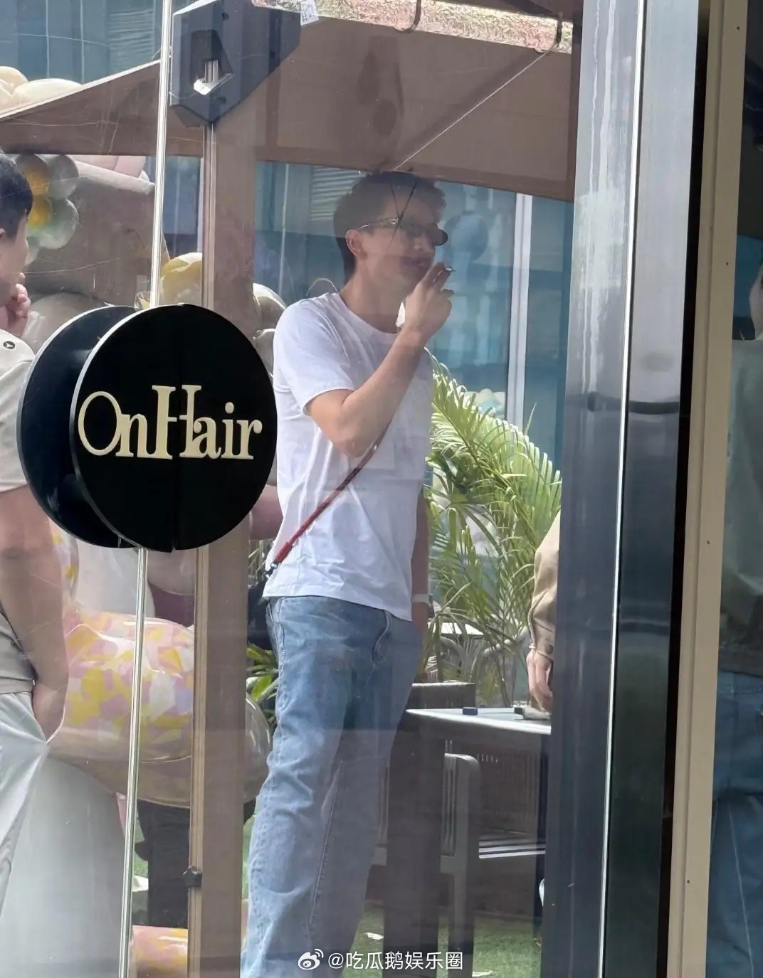 林更新和一帮朋友现身广东理发店，他打扮休闲，他身穿白色圆领T恤搭配浅蓝牛仔裤，脚