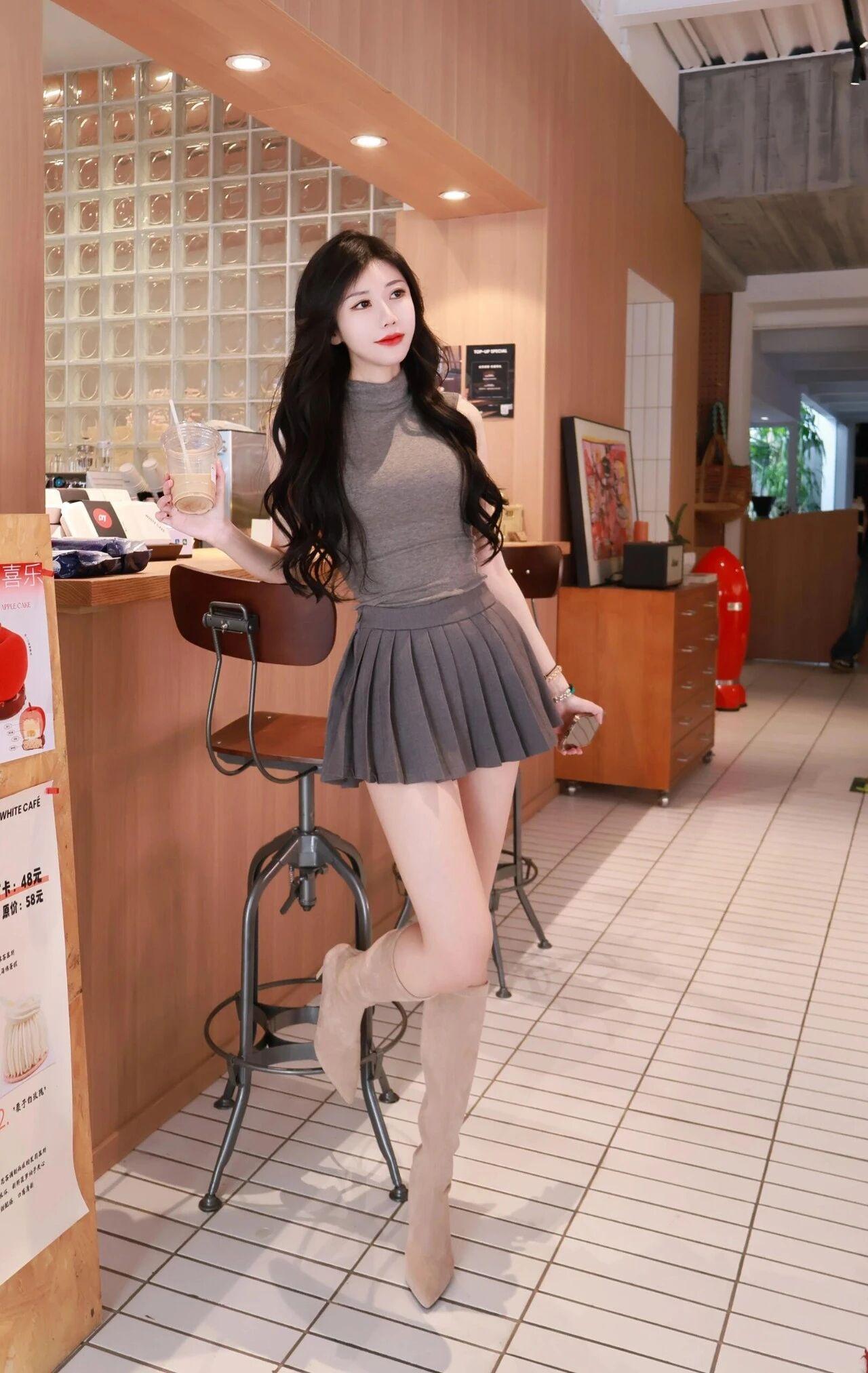 这位美女留着一头乌黑柔亮的大波浪卷发，发丝自然垂落，衬得脸型精致又温柔。眉眼弯弯