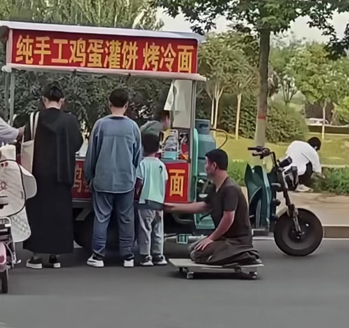 男孩跟爸爸路边买小吃，
碰到“残疾人”乞讨
“残疾人”一直向小男孩乞讨，小男孩觉