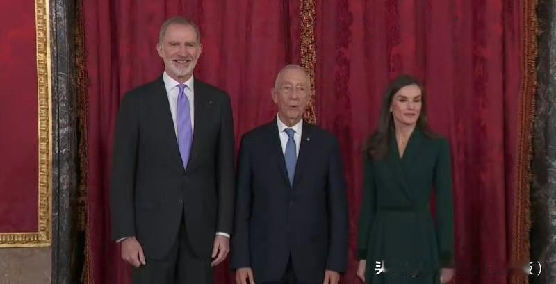 国王夫妇在马德里皇宫接待到访的水果牙大叔，王后的墨绿大衣连衣裙来自王室裁缝。当然