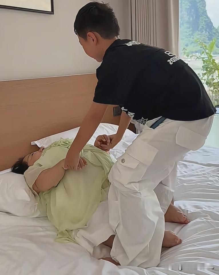 李喜梅躺在床上，儿子贴心跪在床边，细心帮她按摩，又小心扶她坐起身，动作轻柔，生怕
