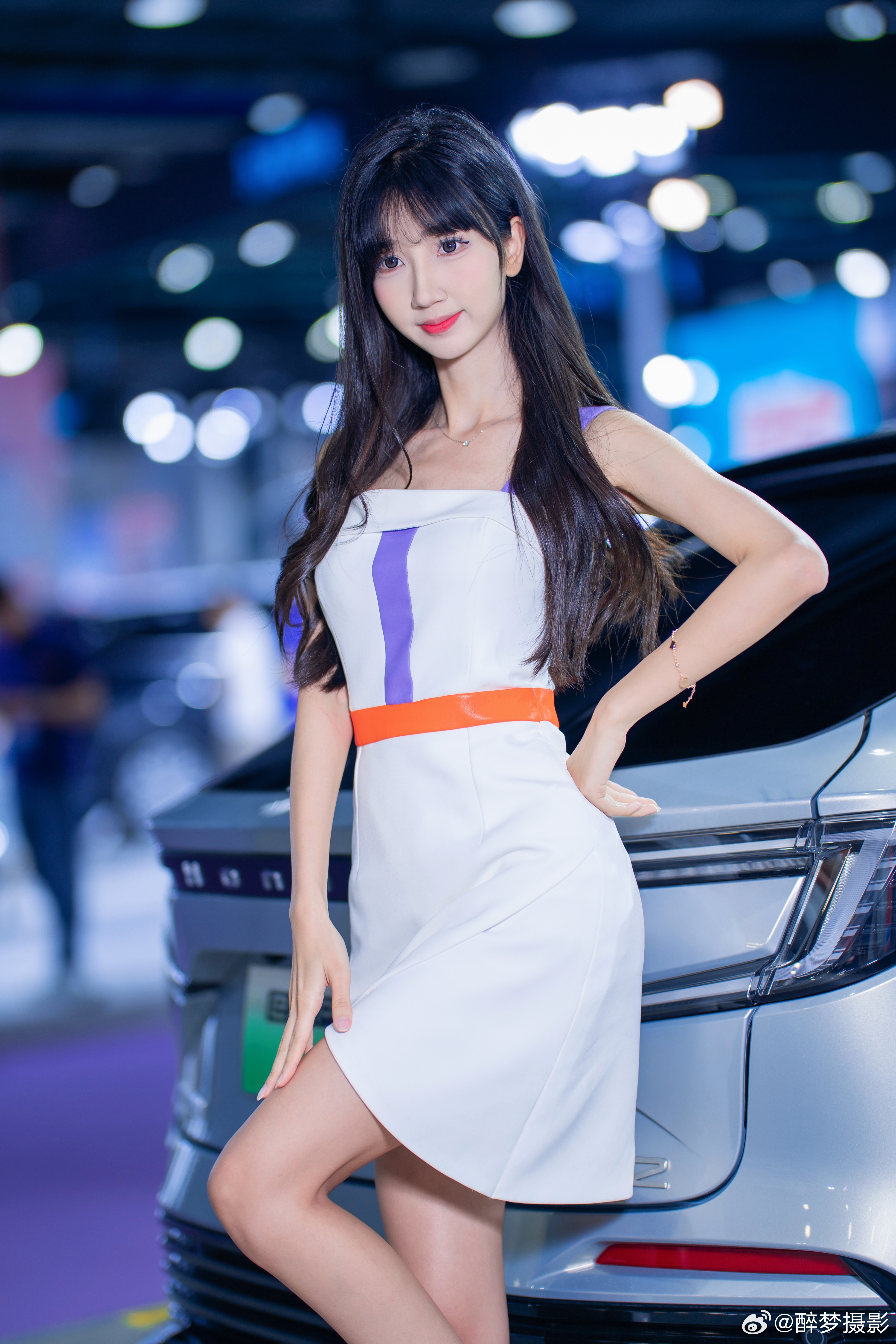 优雅与科技的邂逅✨  白色礼裙搭配橙紫撞色腰带，尽显灵动气质～  身旁的NP2车