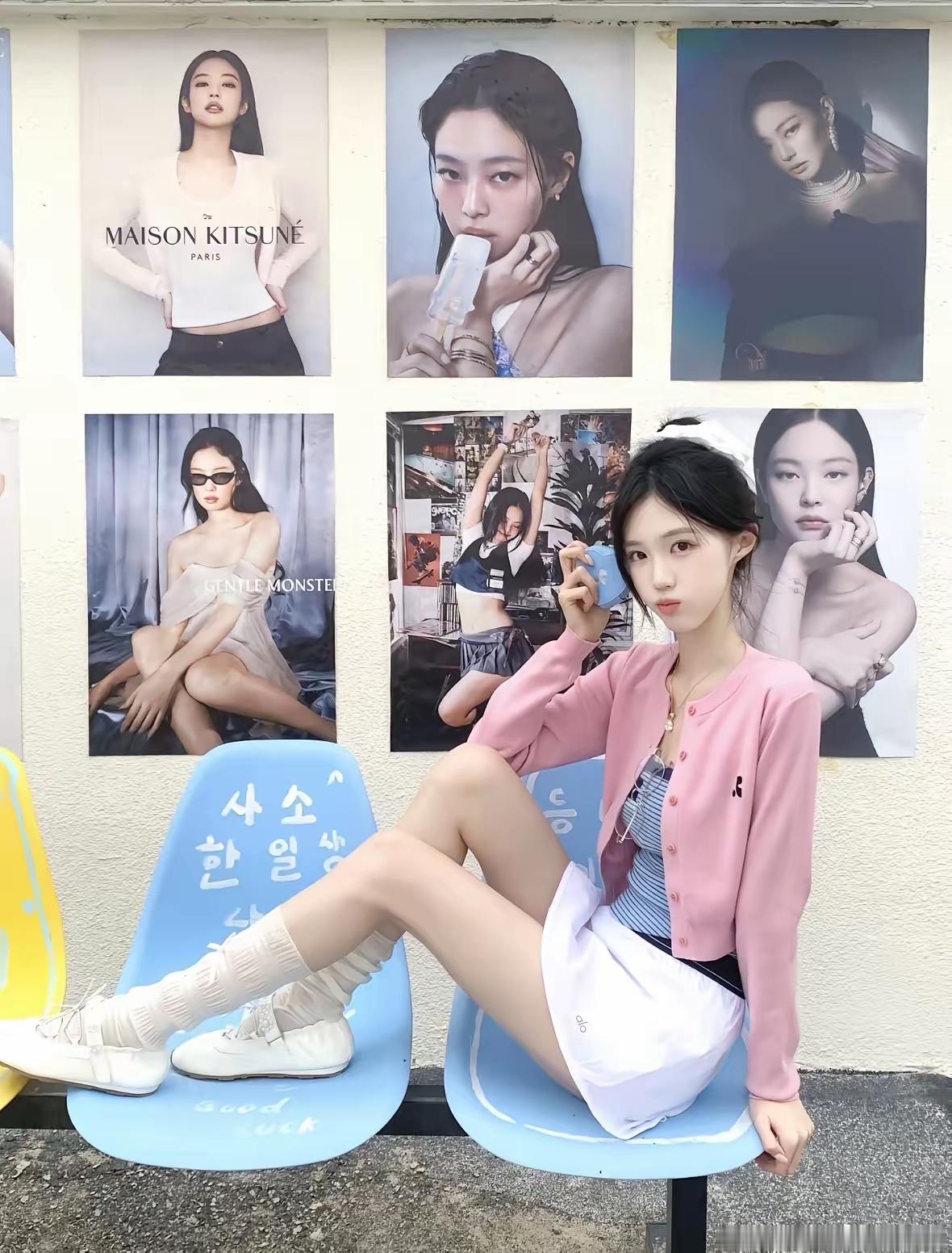 一个女孩坐在椅子上，背景是海报。看看你的练功服