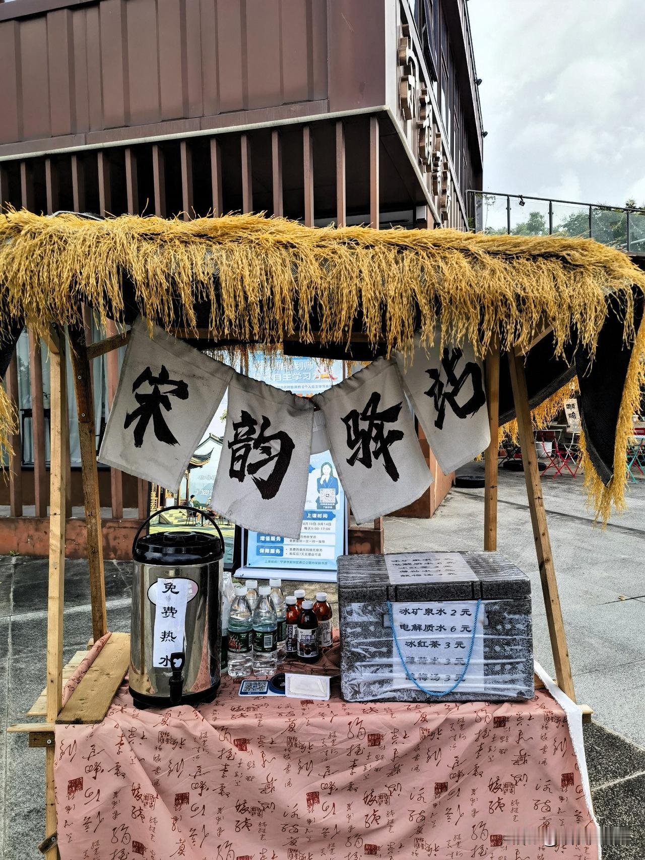 昨天江边散步，偶遇步道旁一个古色古香的宋韵驿站茶水摊，小摊无人值守，却既有暖心的
