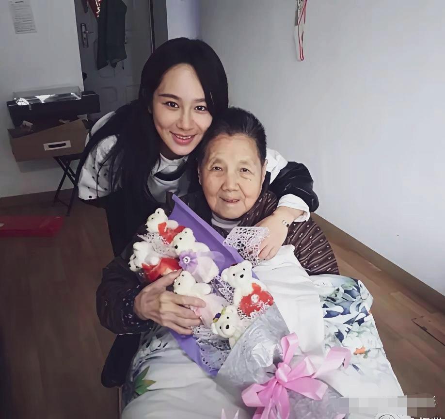 杨紫与长的温馨合照。
杨紫温柔依偎在老人身后，手臂亲昵环住长辈，老人手捧着可爱的