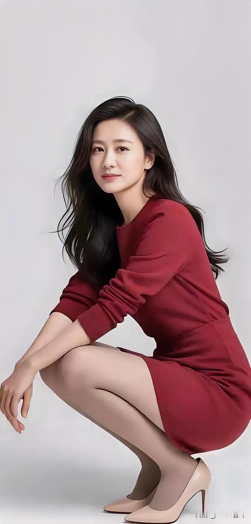 红裙曳光影，蹲姿绽从容。

黑发随心动，高跟叩静空。

素白为背景，美在简中浓。