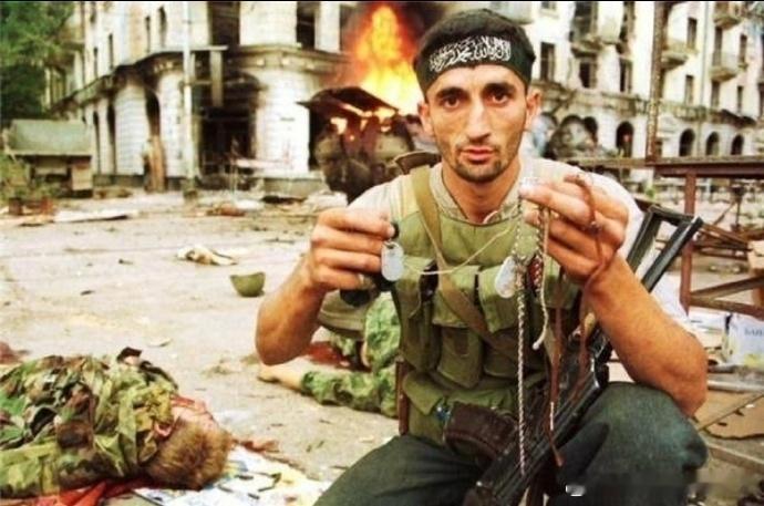 1993年，车臣战争，一位车臣士兵向镜头展示他从身边俄军士兵尸体上扒下的身份牌。