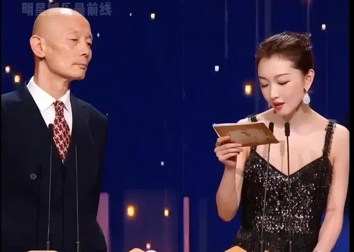 我觉得葛优伸头想去看周冬雨手上的颁奖词，看看她有没有说漏的。[不失礼貌的微笑]，