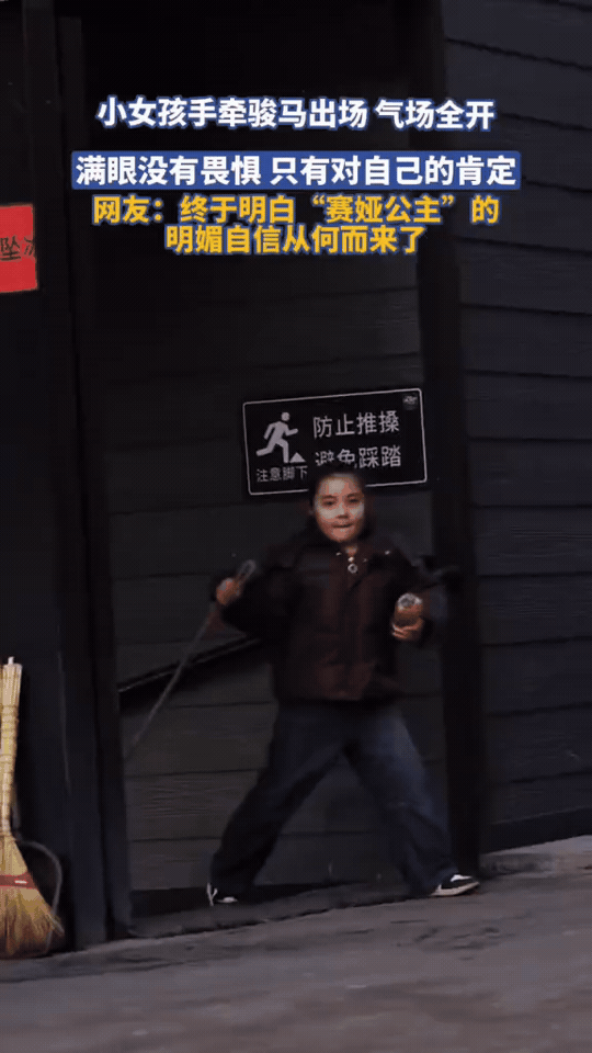 牵着比自己还高的骏马出场，这气场直接拉满
 
马厩门口，小女孩牵着缰绳走在前面，