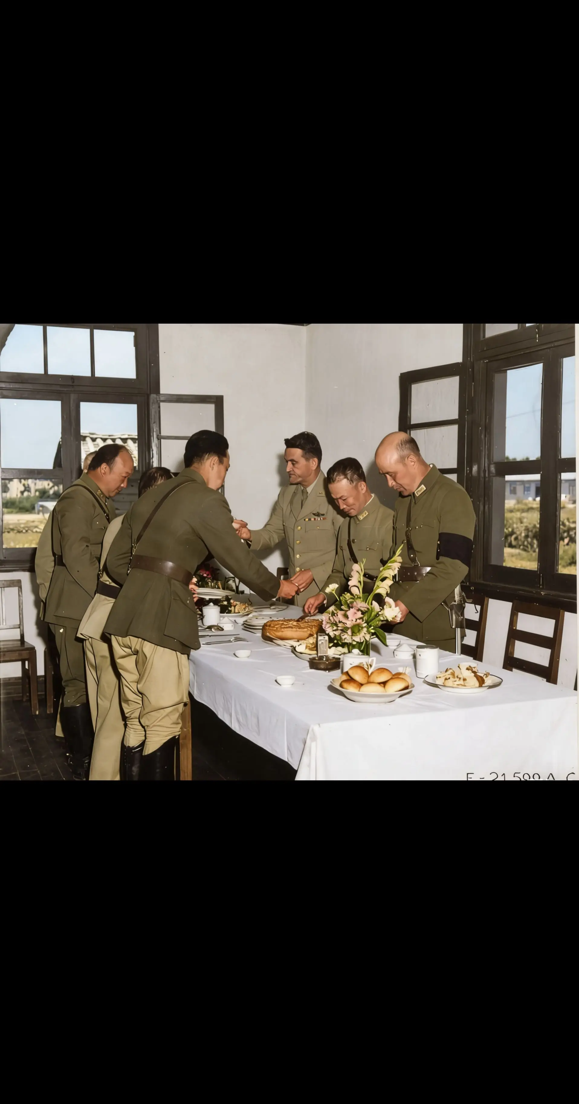 几位军人围桌分享食物，朴素中见温情，历史瞬间定格于一餐一饭之间 。