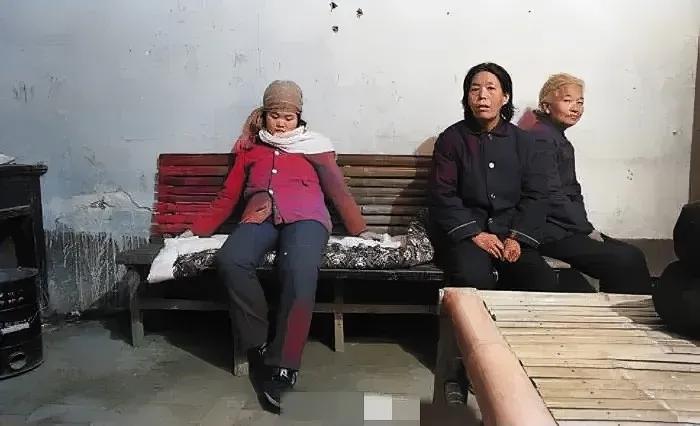 90年代，一个等待“结扎”的妇女，静静地坐在长凳上，她的眼神略显疲惫，刚出月子的