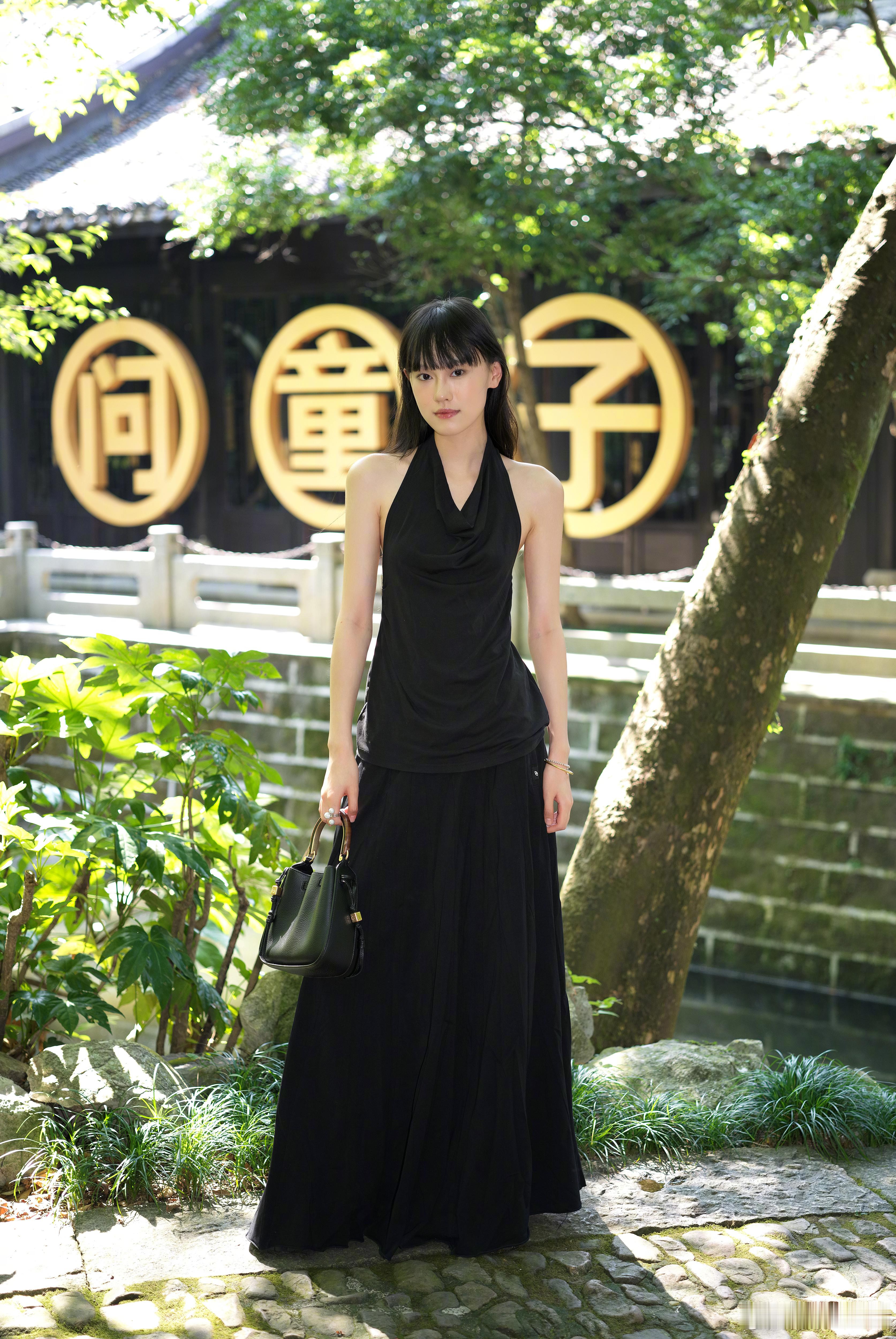8月24日，问童子品牌展街拍更新，黑色有时候是最为刚强的色彩，但当它与温柔的裙装