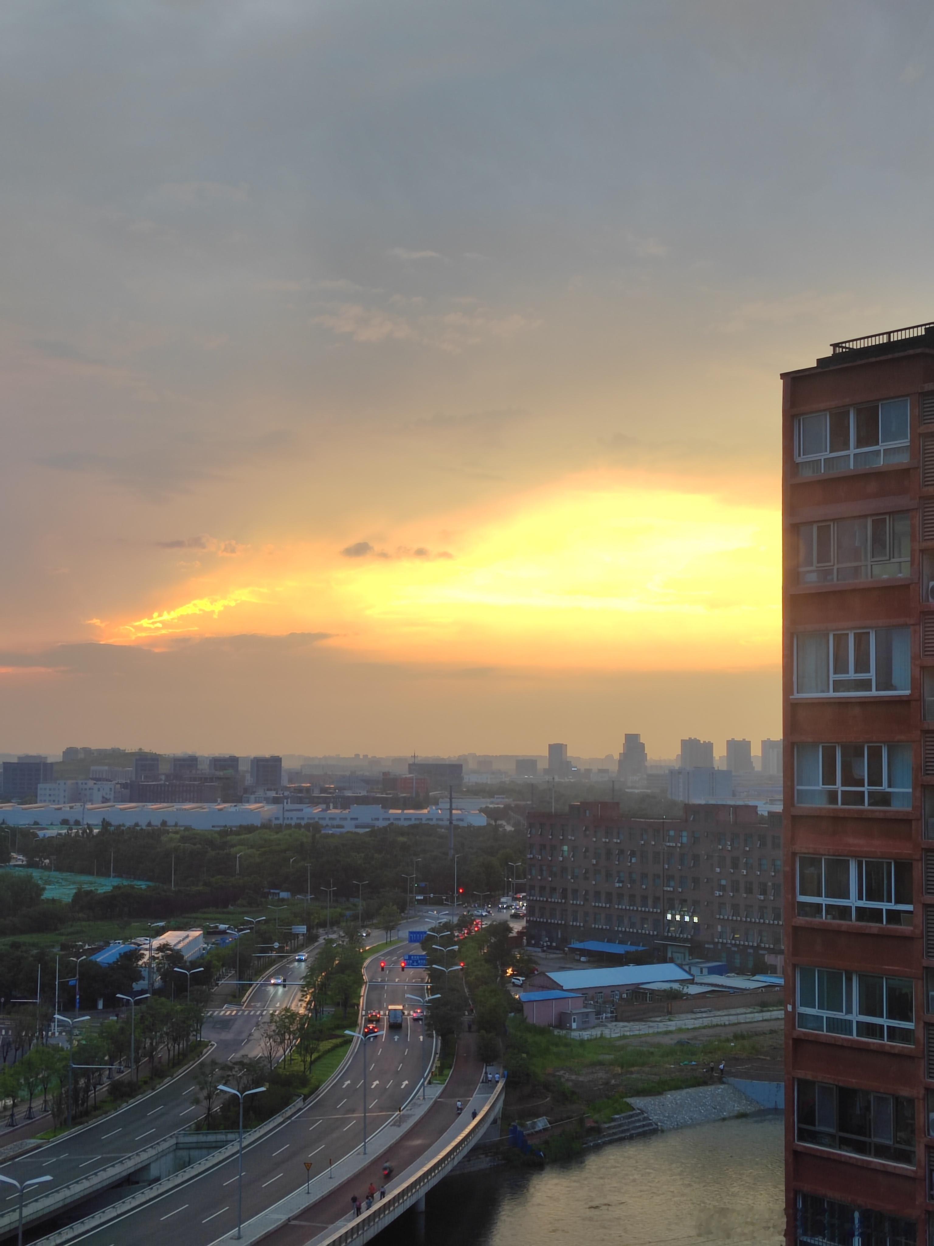 骤雨褪去喧嚣，落日泼洒暖色晚霞。整座城市浸在暮色里，抚平一日疲惫。 