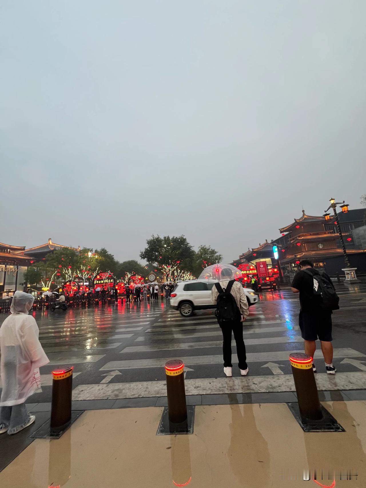 今天下午5时左右一场雨降临西安城

华灯初上的大唐不夜城依然

有不少游客冒雨游